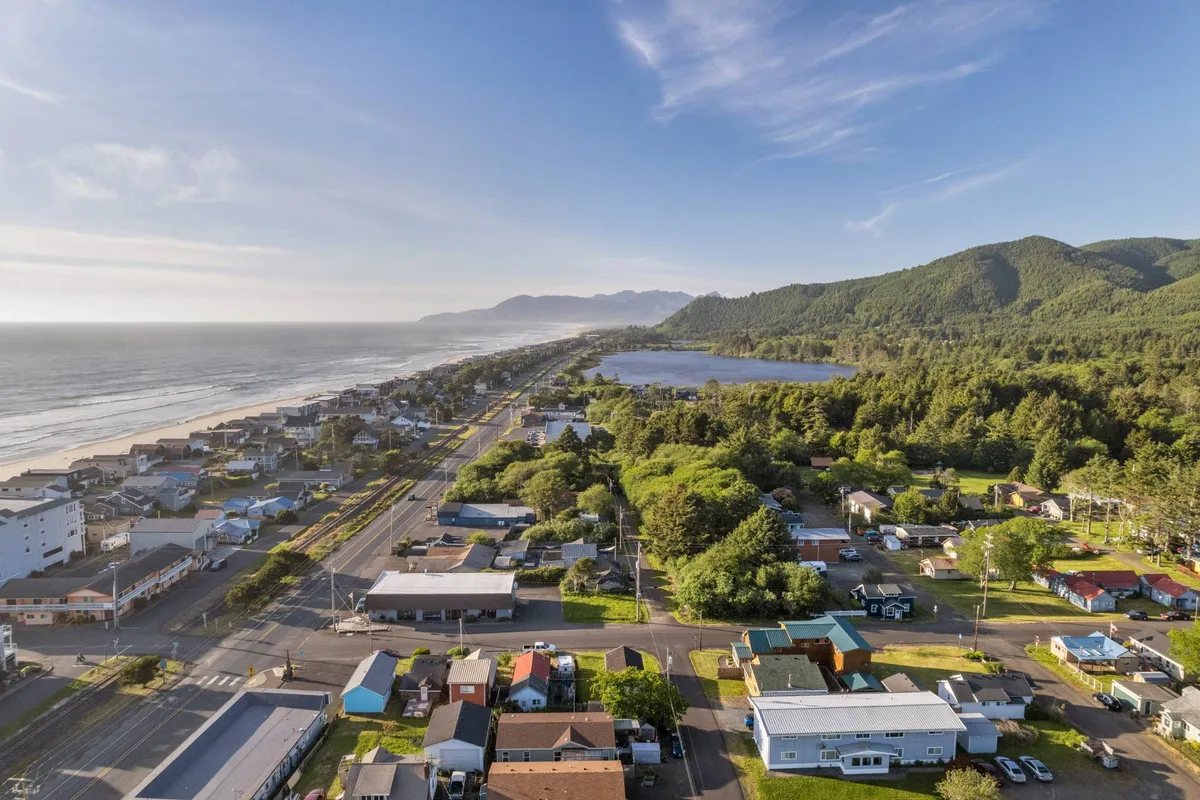A panoramic view captures local businesses nestled among residential areas, lush greenery, and distant mountains. The image highlights the inviting nature of the community, with clear sightlines to both the vibrant town center and the natural landscape beyond.